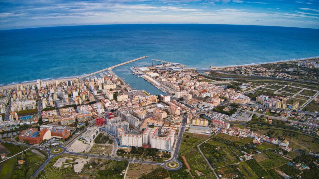 Vista aérea de la playa de Gandia, donde se muestra el puerto y edificios cercanos al mar